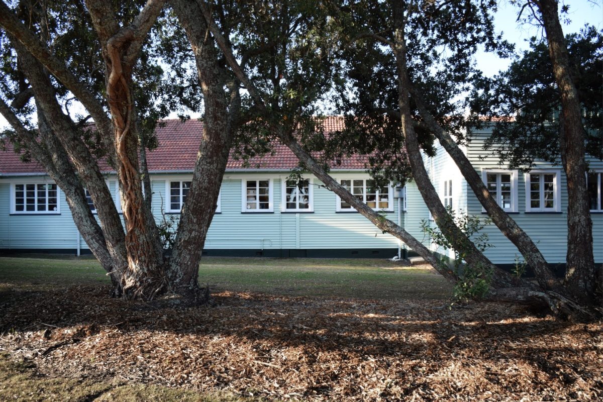 An institutional building set among mature trees