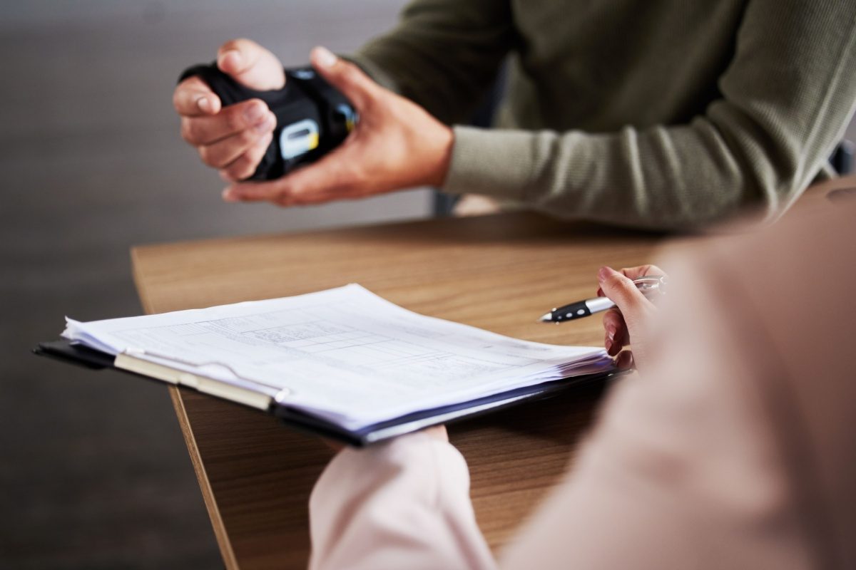 Two people going through a document across a desk, with a set of car keys